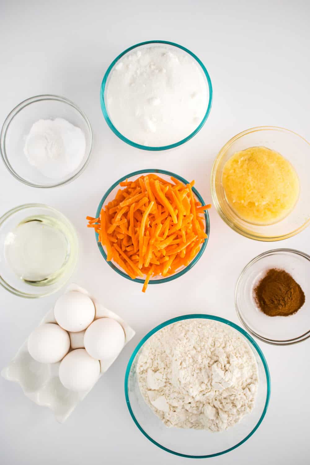 Ingredients in glass bowls to make carrot cake