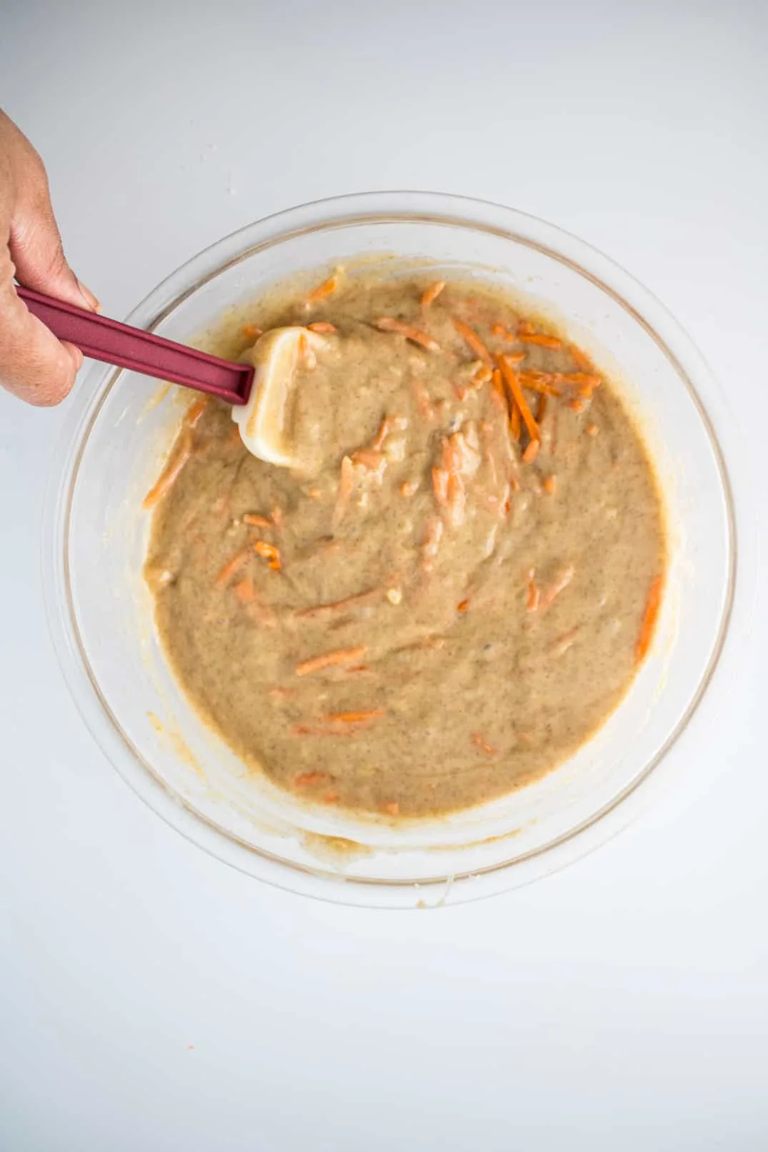 Folding the carrot cake batter with a spatula