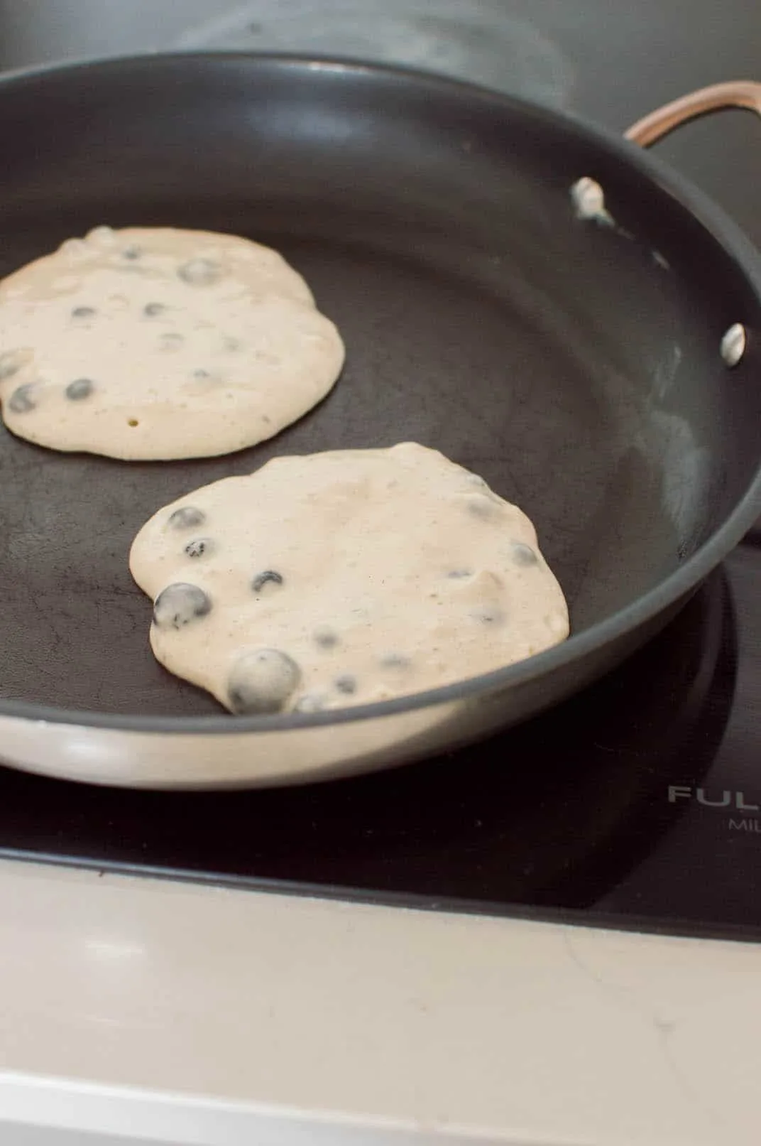 Cooking blueberry pancakes in non-stick pan