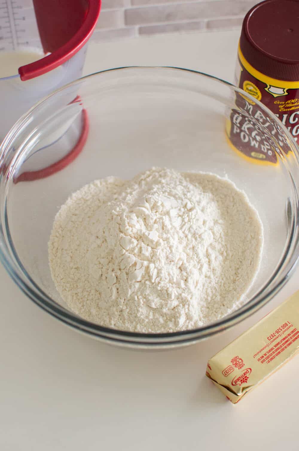 All-purpose flour in a glass bowl, surrounded by additional ingredients