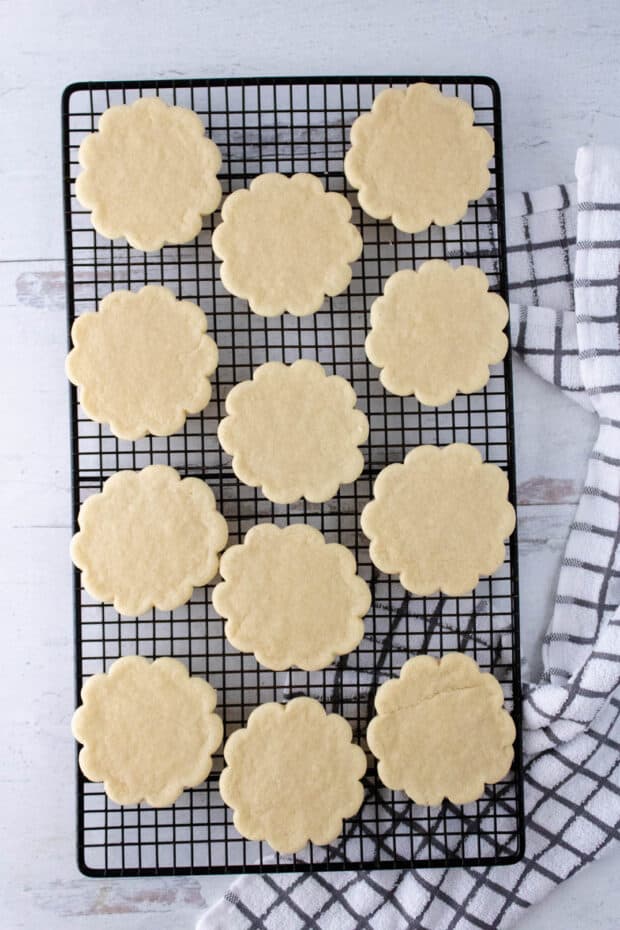 Newly baked tea cookies cooling on a black wire rack
