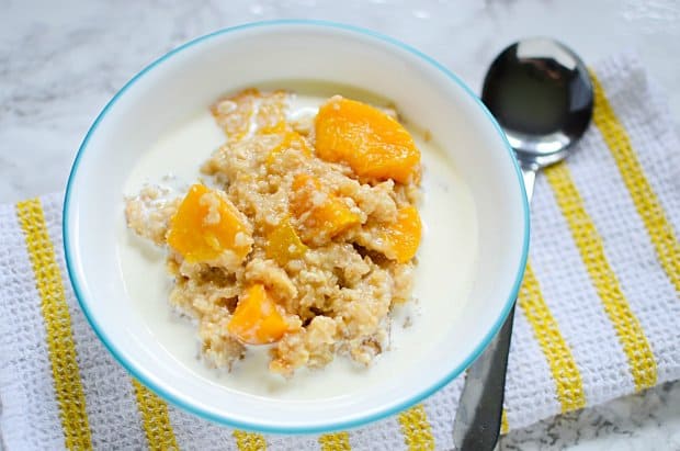 Ginger Peach Steel Cut Oats made in the slow cooker in a white bowl on a yellow and white towel