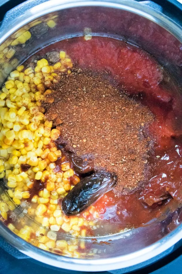 Add in crushed tomatoes, corn and spices