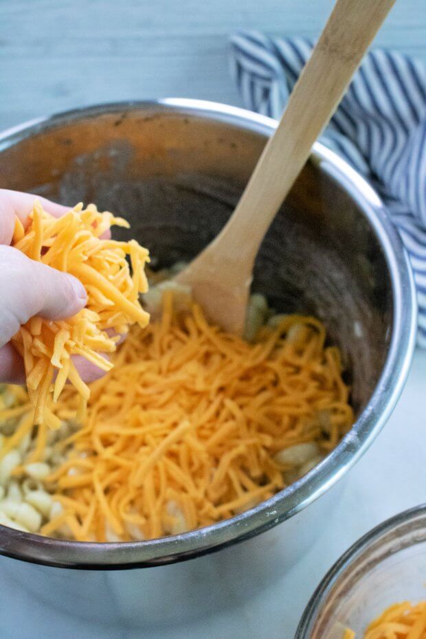 Add shredded cheese to cooked pasta