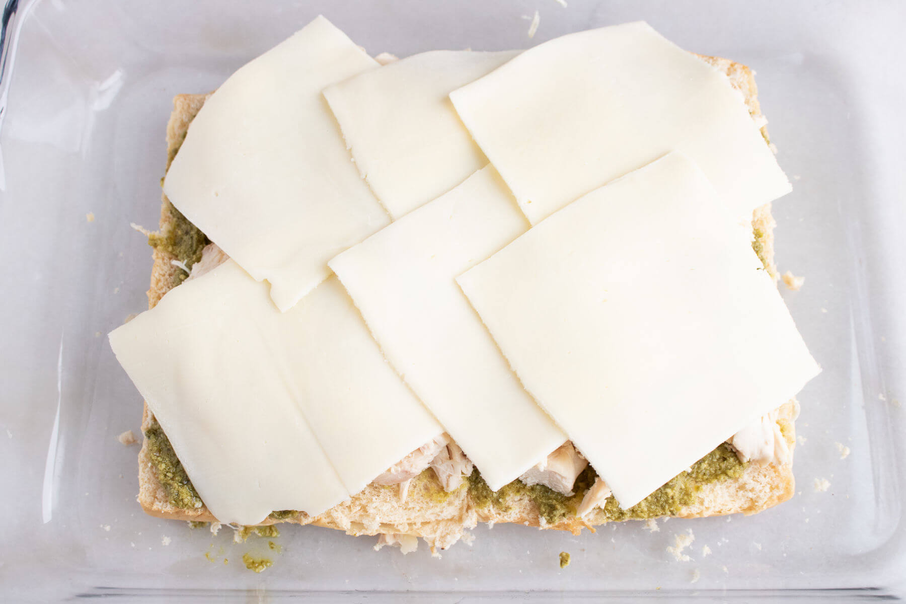 Cover chicken and pesto with cheese