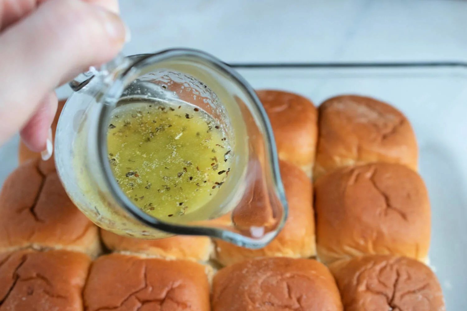 Pour herbed butter over sliders before baking