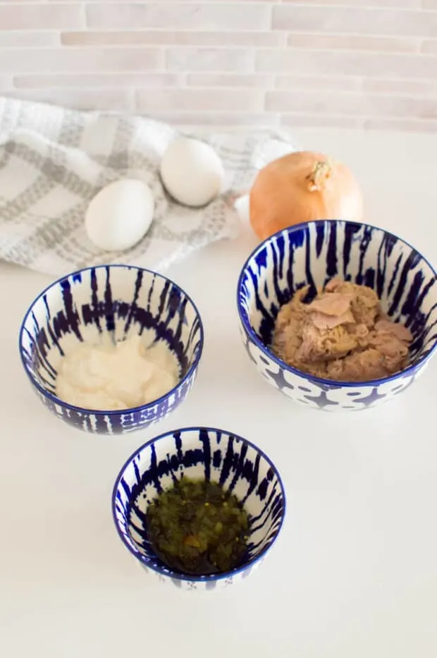 Ingredients in blue and white bowls to make tuna salad with eggs