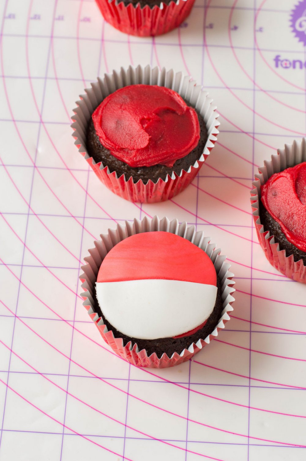 Adding white and red fondant to pokemon cupcakes