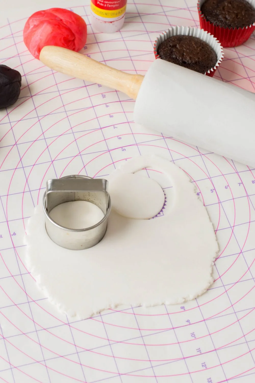 Using a cookie cutter to cut out white fondant