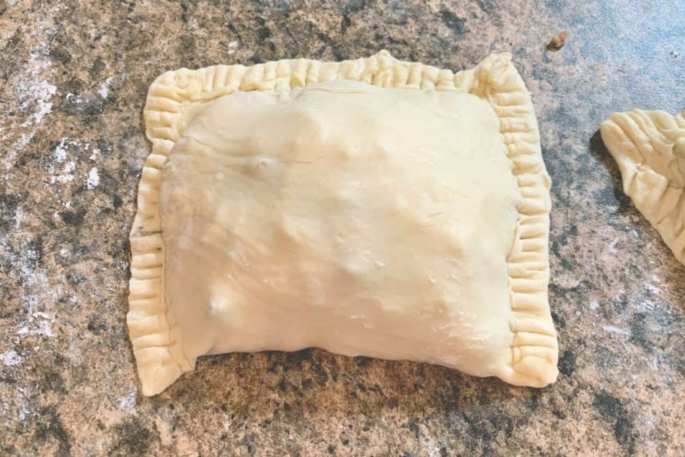 Folding up the chicken puff pastry pocket.