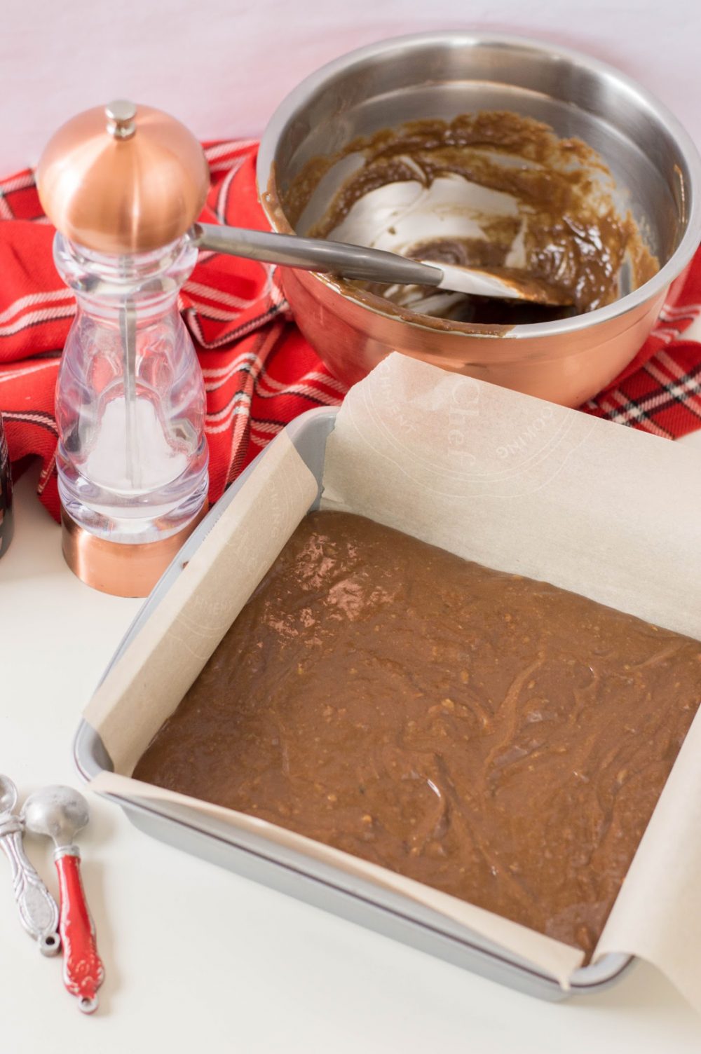 putting avocado brownies batter into parchment lined pan