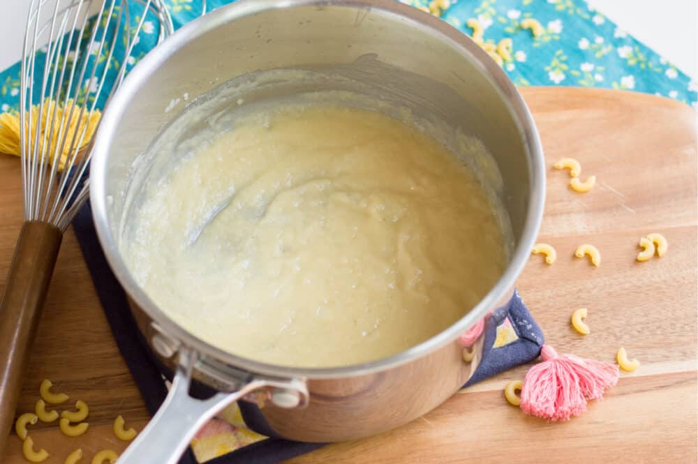 whisking melted butter and flour together to create roux for cheese sauce