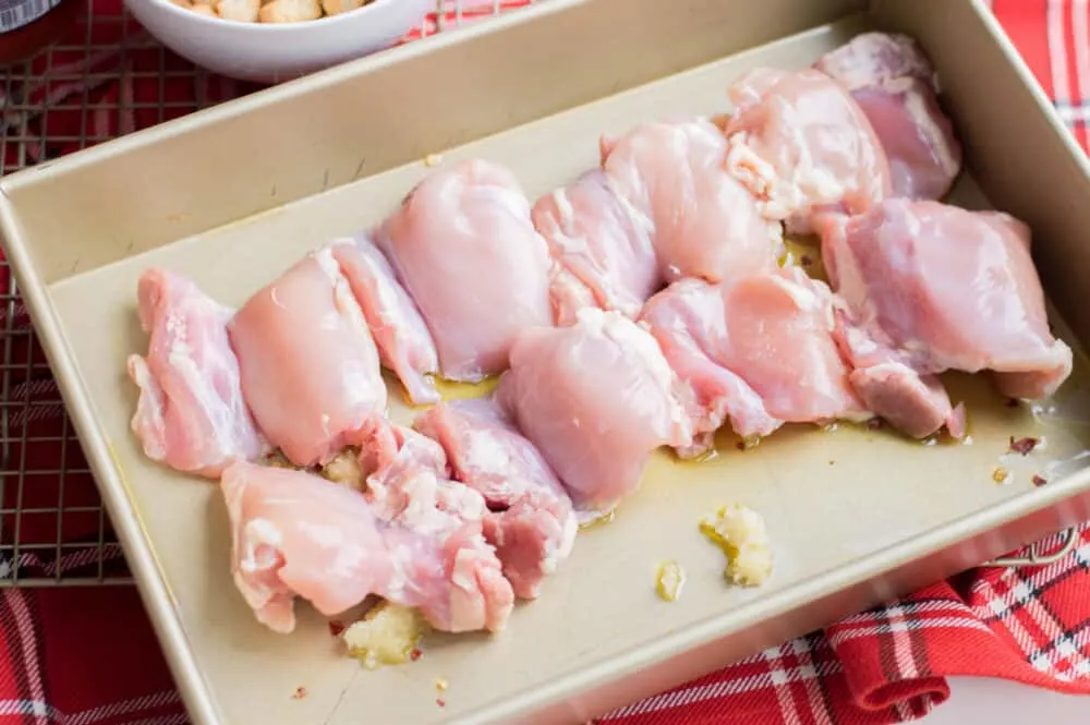 Raw chicken lined up in baking dish