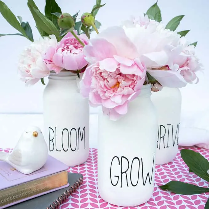 Chalk Painted mason jars with peonies on pink patterned tablecloth