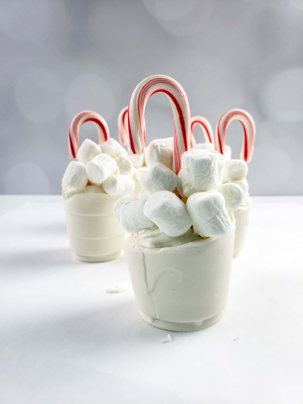Topping off hot chocolate bombs with marshmallows and candy canes