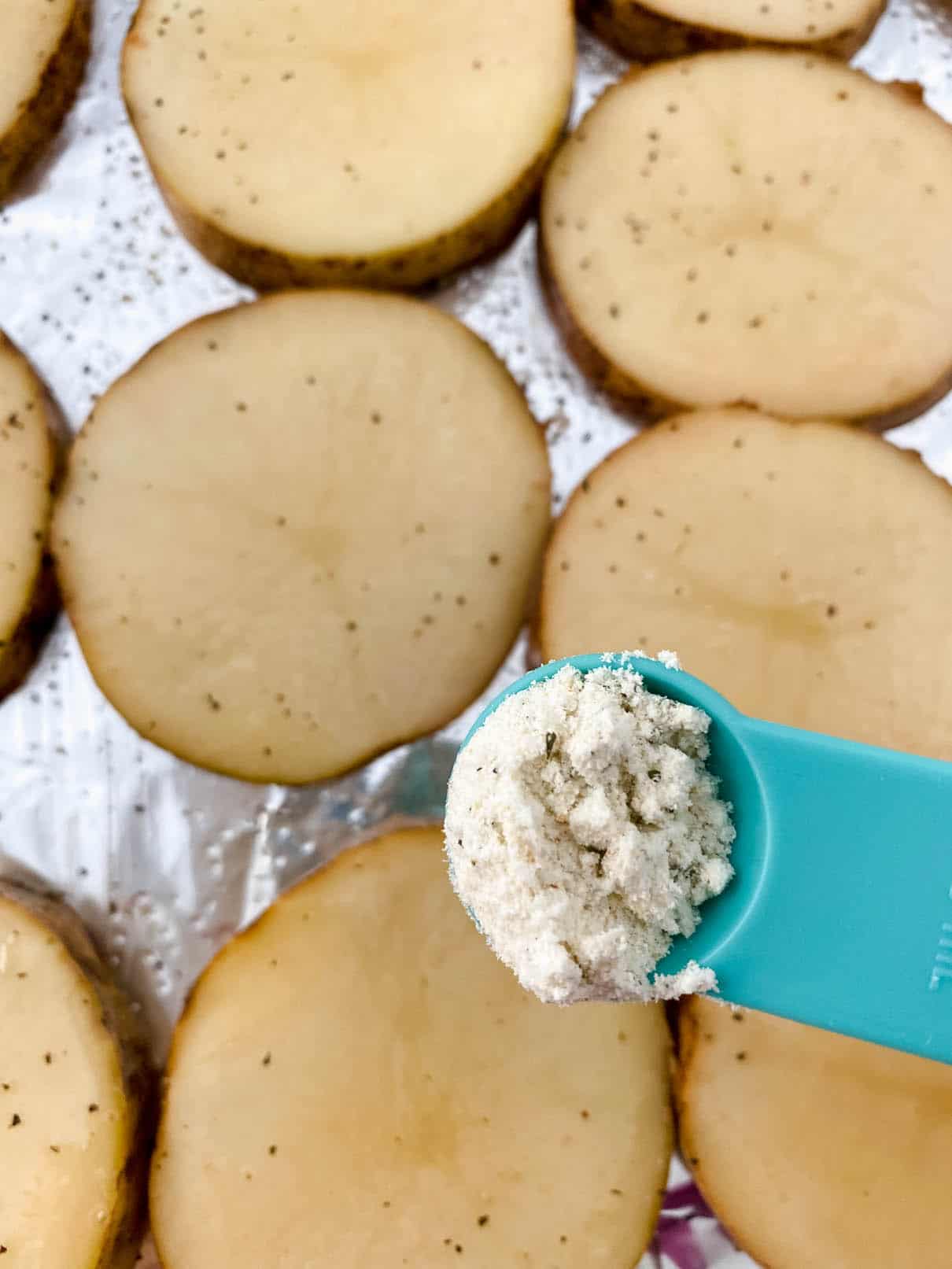 Garnishing sliced potatoes with ranch dressing