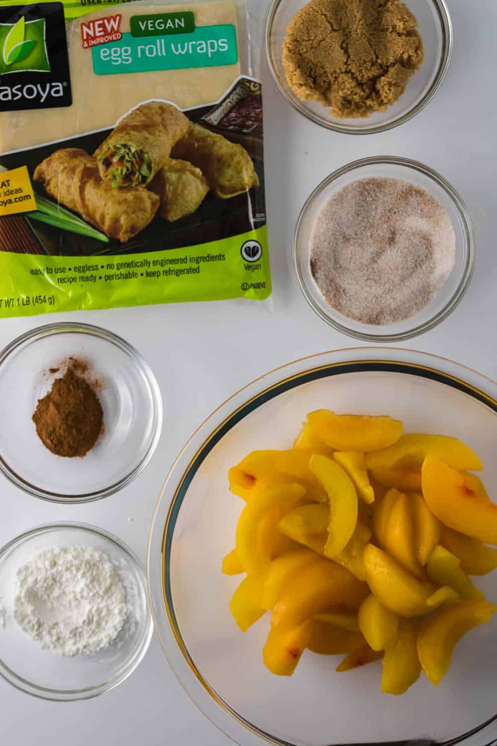 Ingredients laid out in bird's eye view to make Peach Cobbler Egg Rolls