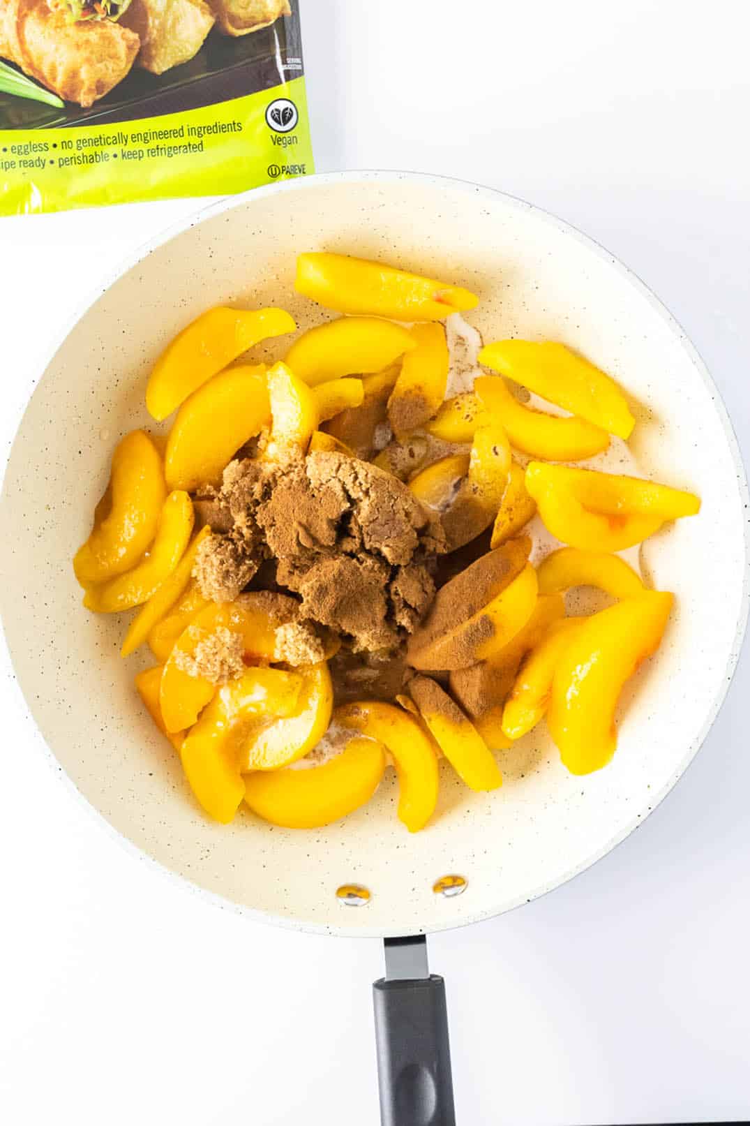 Peaches and brown sugar in a white ceramic bowl