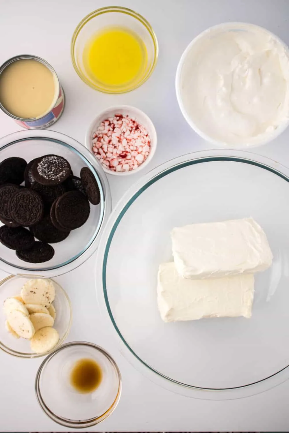 Ingredients required to make No-Bake Peppermint Cheesecake Jars. Ingredients are presented in glass bowls.