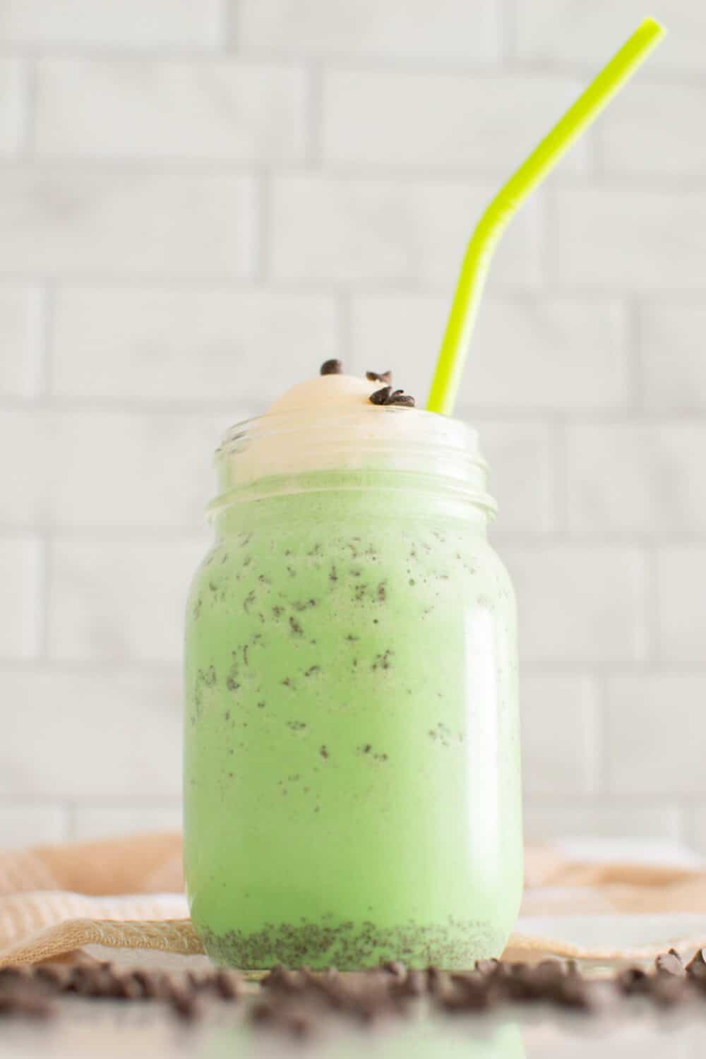 A St. Patrick's Day green milkshake in a mason jar with a neon green straw