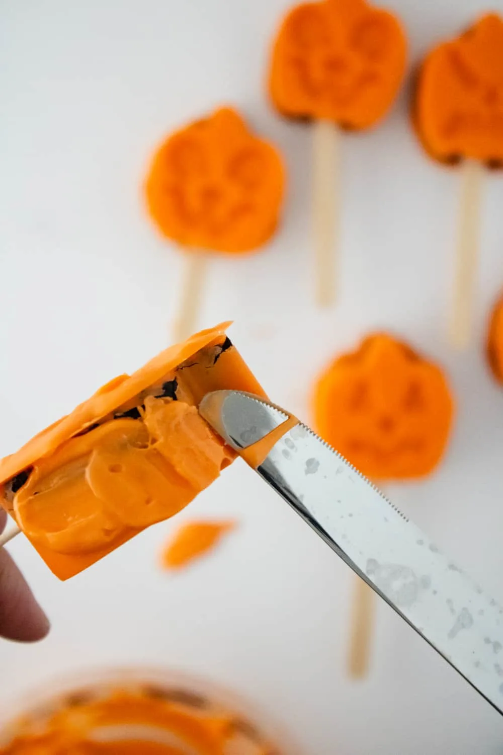 Fixing any missing chocolate on the edges of the pumpkin cake pops.