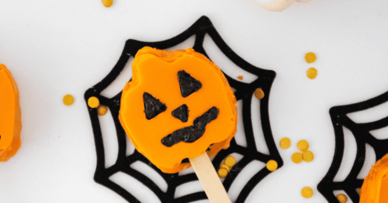 Orange pumpkin cake pop on chocolate spiderweb
