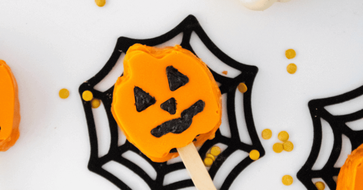 Orange pumpkin cake pop on chocolate spiderweb