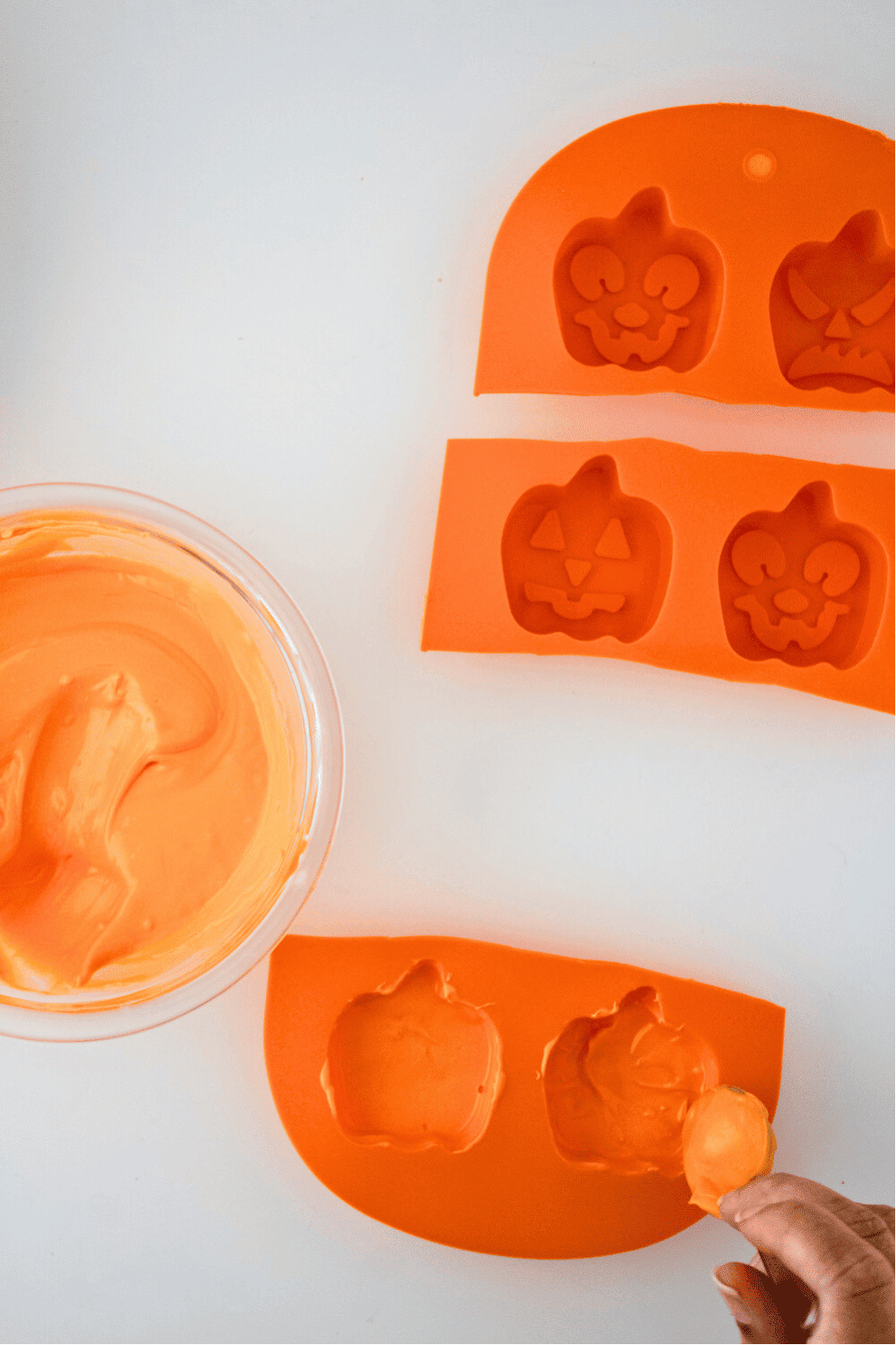 Coating silicone mold with orange candy melts for pumpkin cake pops