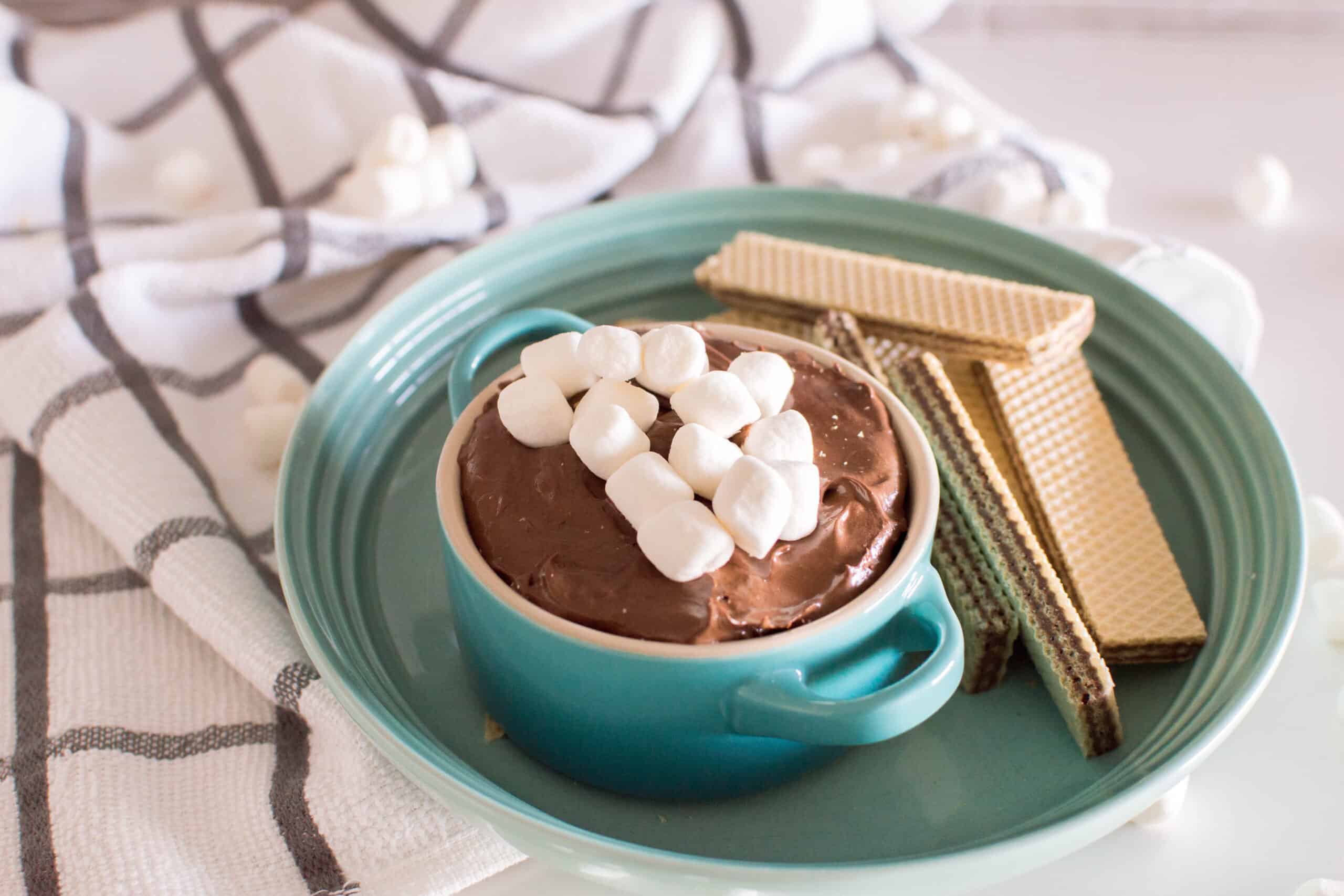 Hot Cocoa Dip in a teal bowl with cookies for dipping