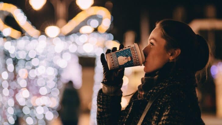 Woman drinking out of a paper cup at a Christmas Market