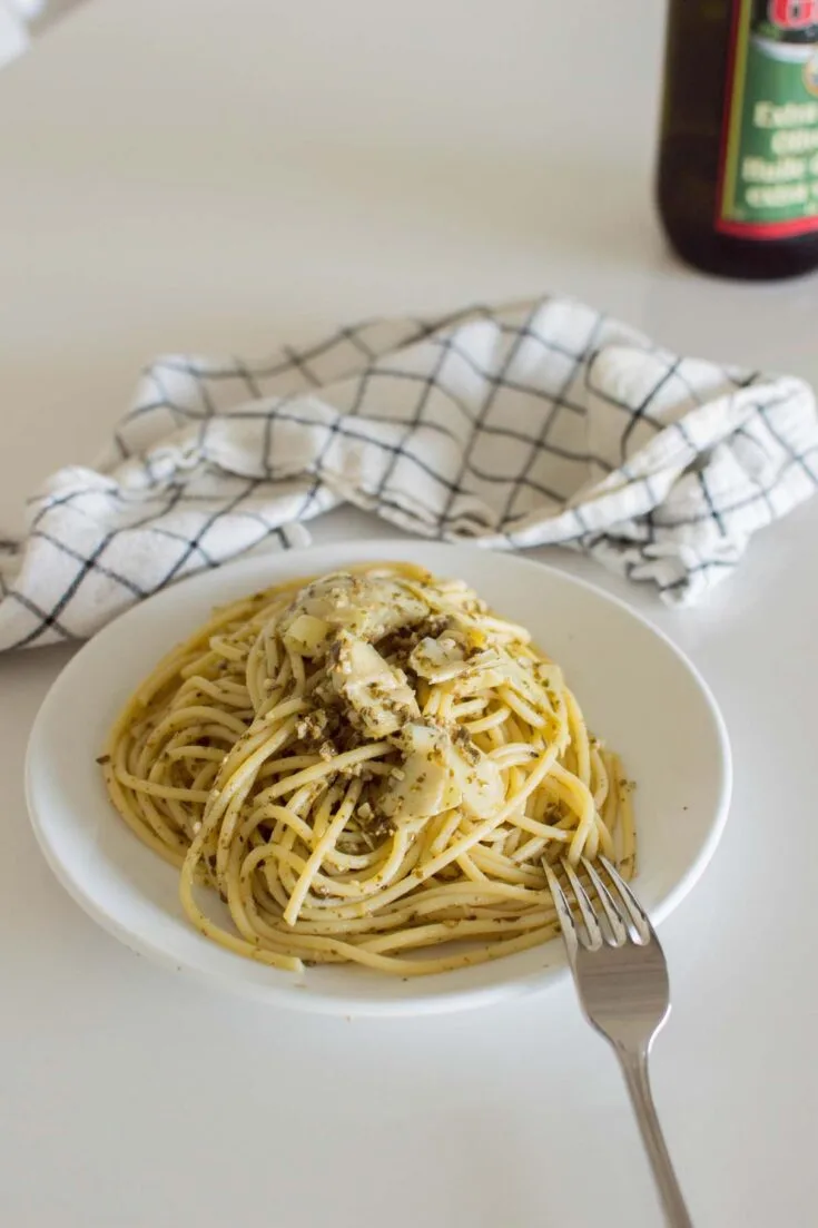 Bird's eye view of a serving of Artichoke Pesto Pasta on a white plate