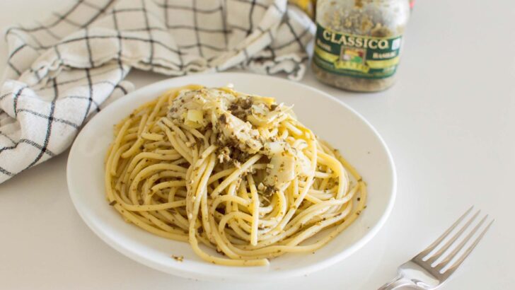 Artichoke Pesto Pasta served on a white plate with a napkin in the background