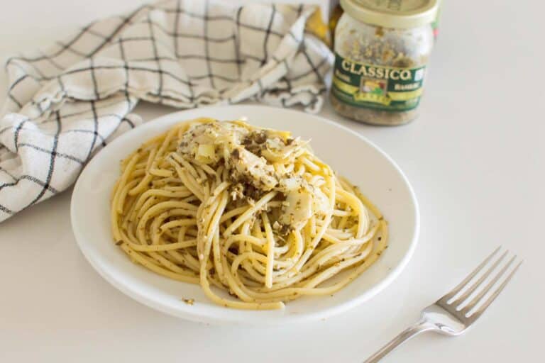 Artichoke Pesto Pasta served on a white plate with a napkin in the background