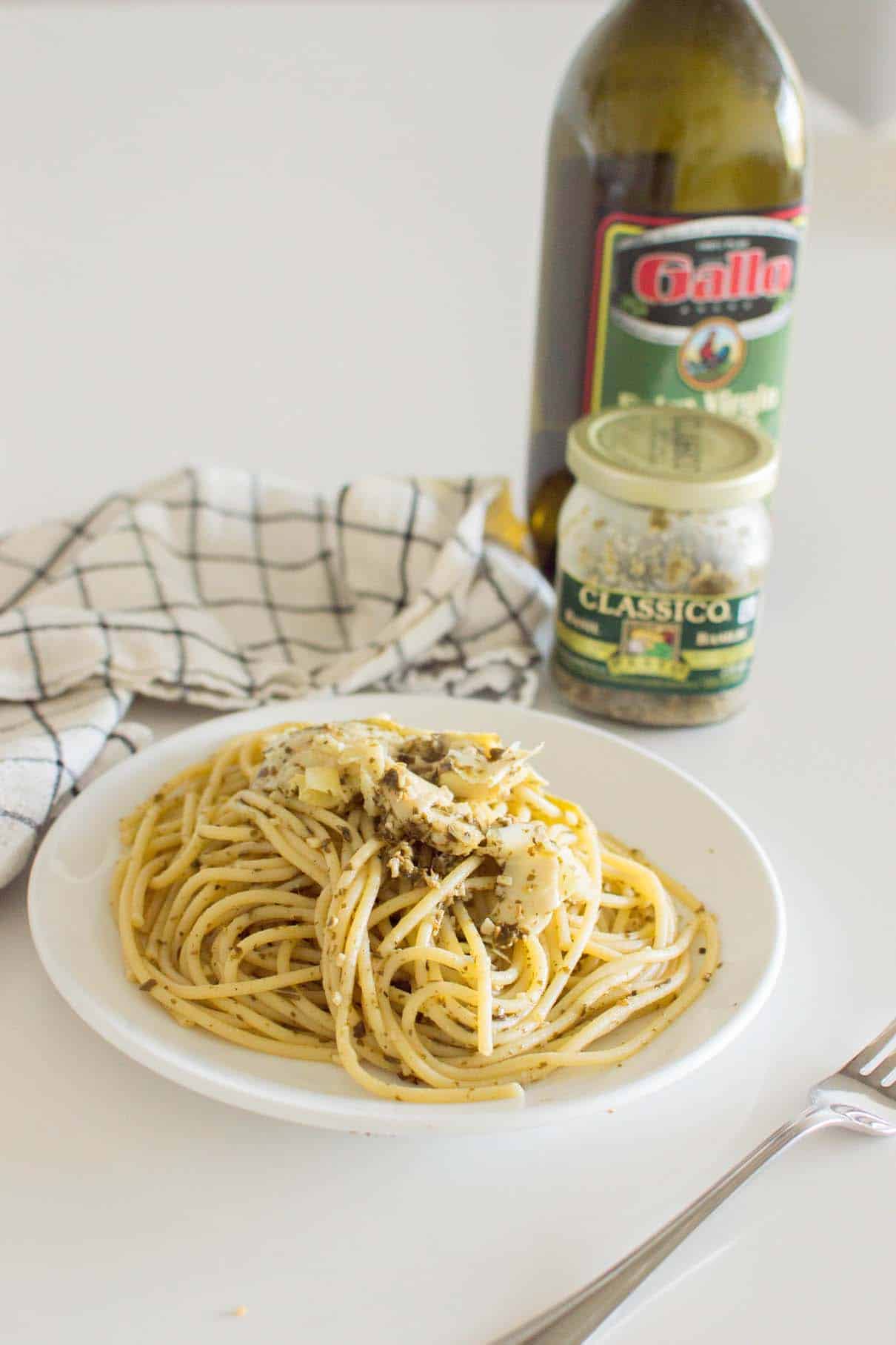Artichoke Pesto Pasta served on a white plate with a napkin in the background
