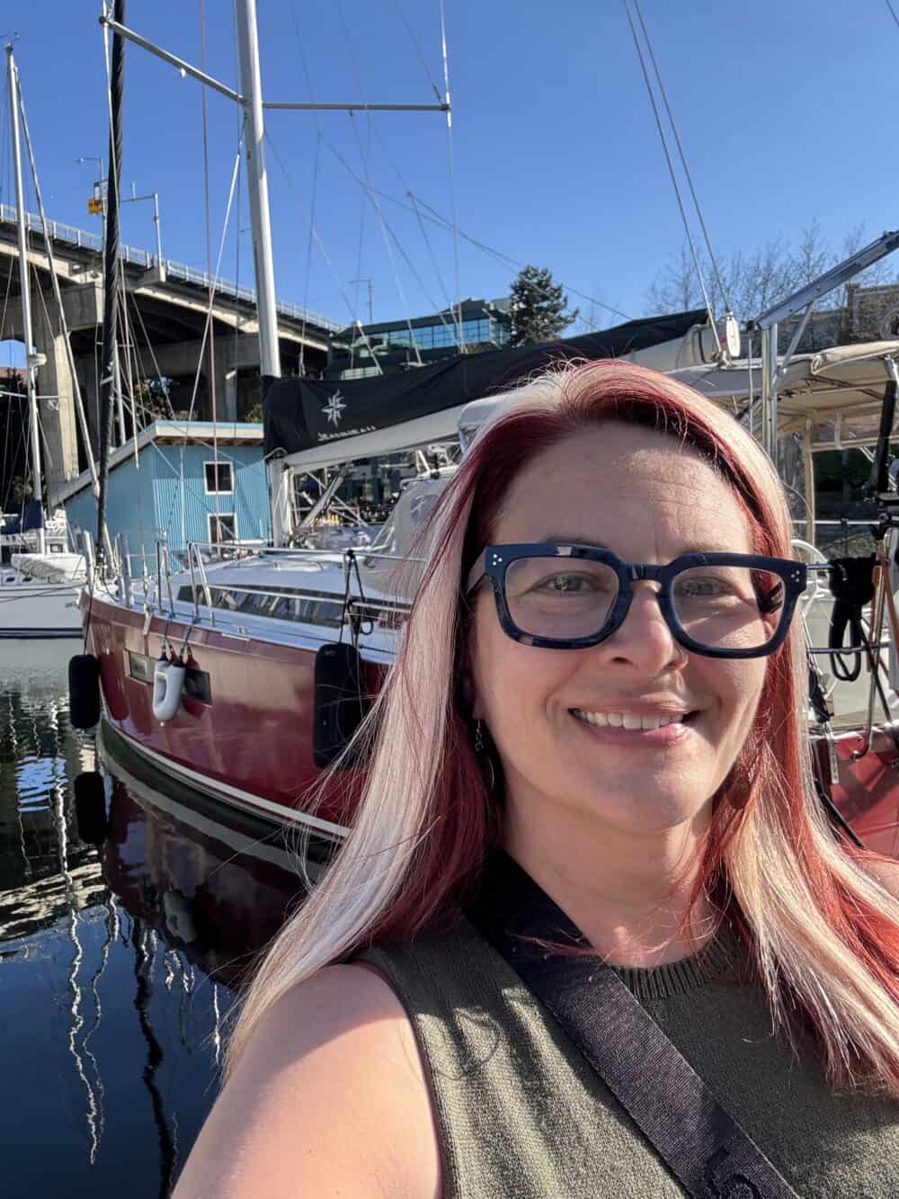Woman in front of a red sailboat