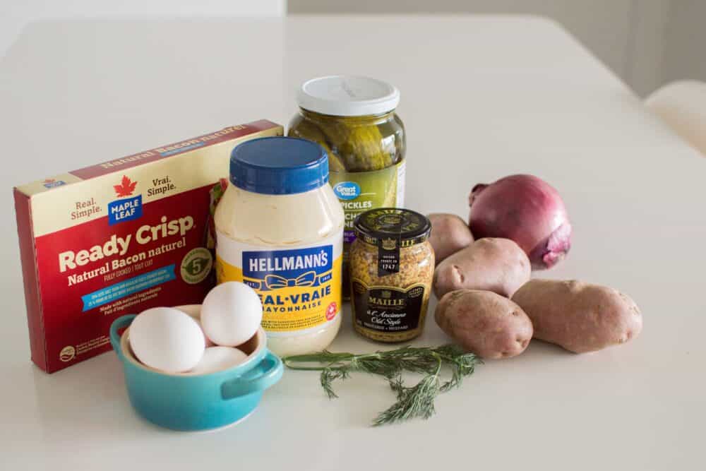 Ingredients for loaded dill pickle potato salad including potatoes, pickles, eggs, and mayo