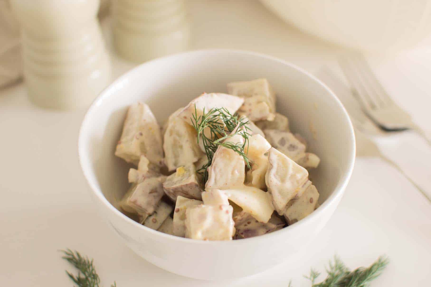 Close-up of creamy loaded dill pickle potato salad with bacon and eggs