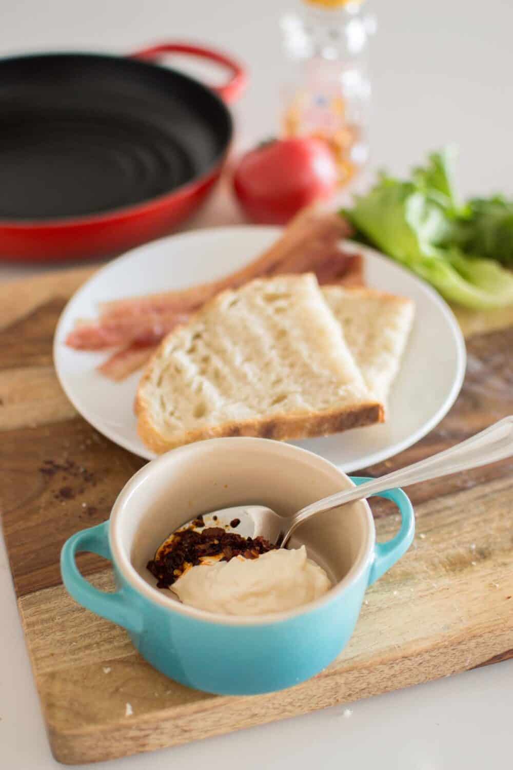 Toasted sourdough bread with spread ready for assembling hot honey BLT