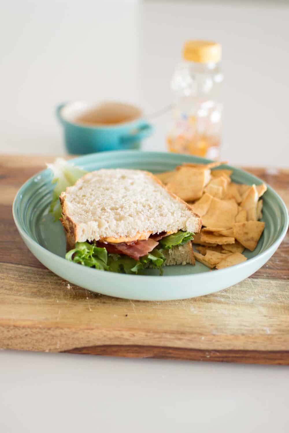 Hot honey BLT served on a plate with visible layers of bacon and tomato
