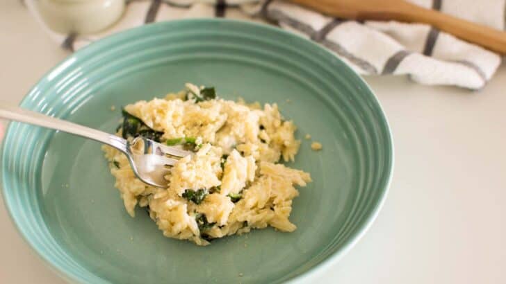 Creamy spinach parmesan orzo garnished with extra parmesan cheese