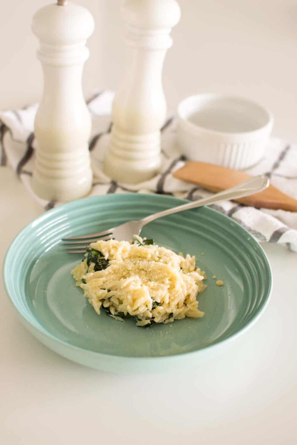 Creamy spinach parmesan orzo served on a dinner plate