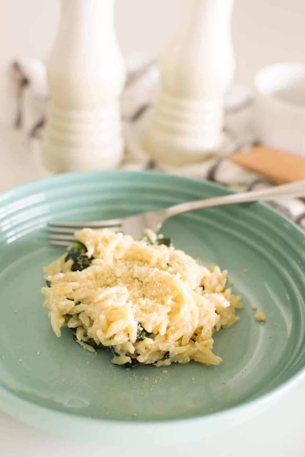 Close-up of creamy spinach parmesan orzo with grated parmesan