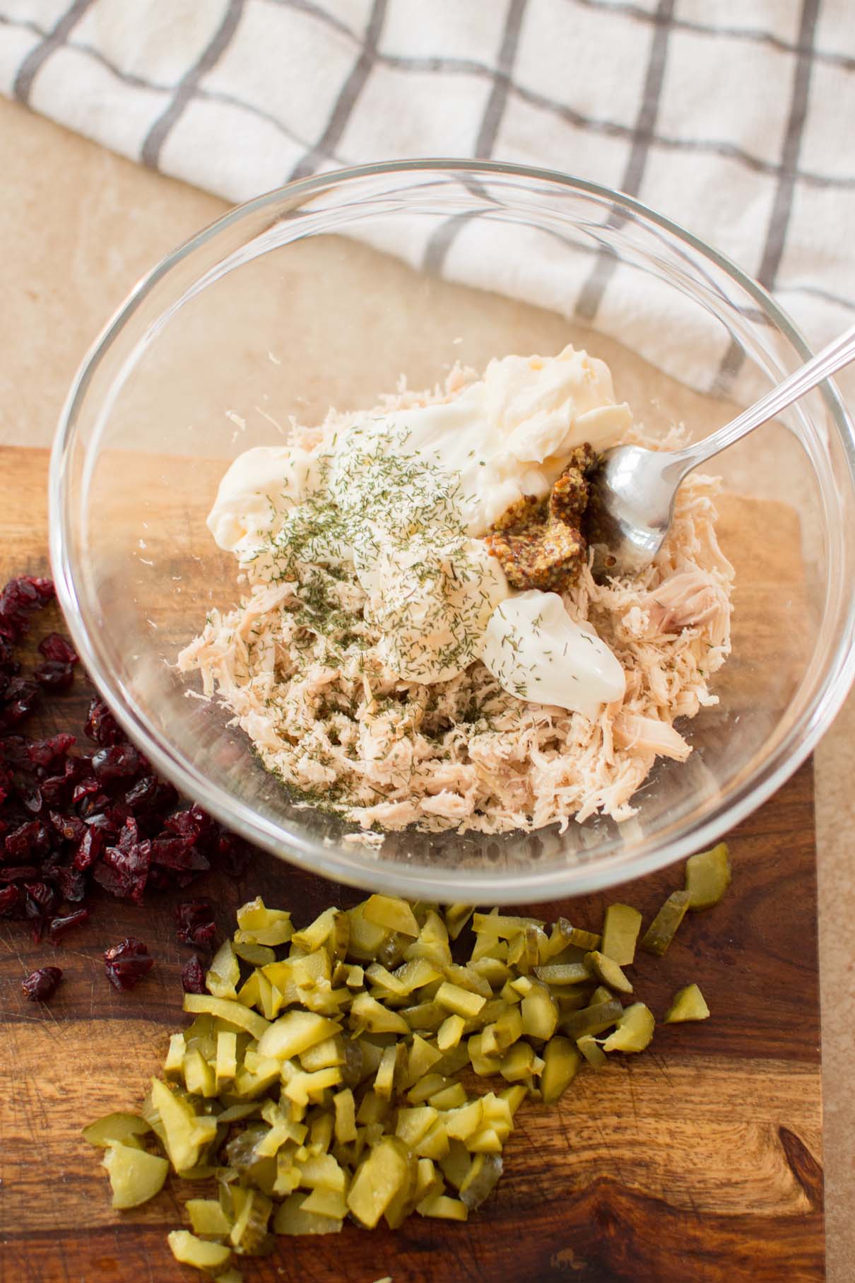 Shredded chicken with mayonnaise, Dijon mustard, and dried dill in a mixing bowl