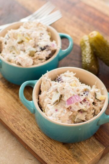 Dill Pickle Chicken Salad served in small bowls with whole dill pickles