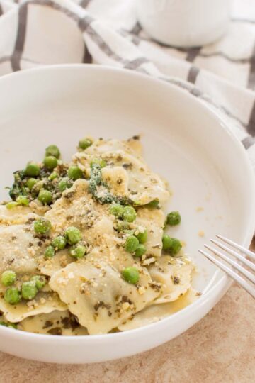 Close-up of Creamy Pesto Ravioli topped with freshly grated Parmesan cheese