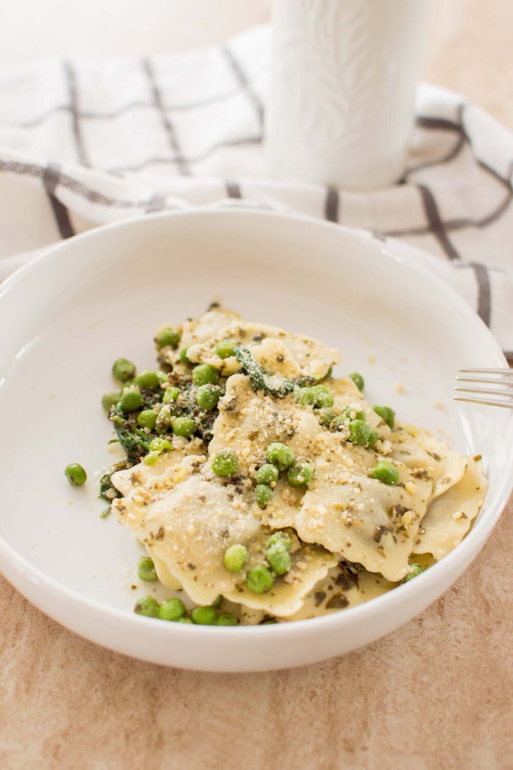 Easy creamy pesto cheese ravioli with green peas and wilted spinach