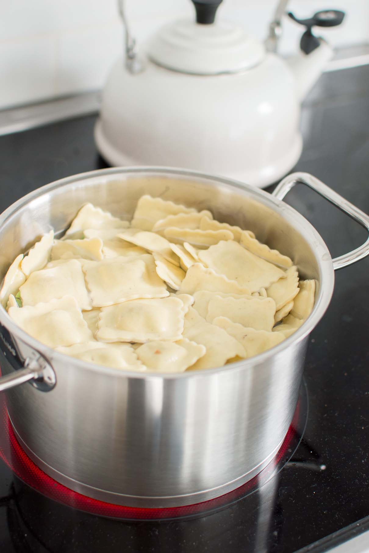Cheese ravioli cooking in a pot of boiling water on the stove